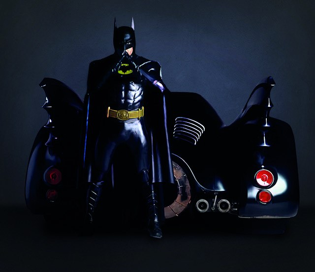 Carl Newman as Batman standing beside the Batmobile